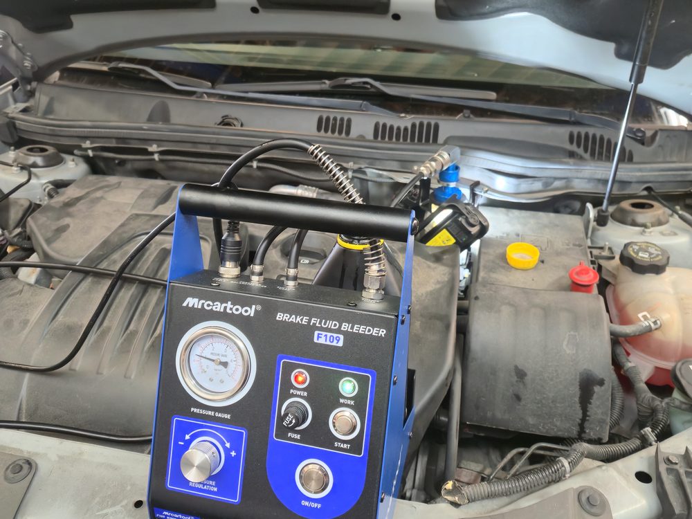 Pressure brake fluid bleeder machine connected to a master cylinder reservoir during a brake fluid flush
